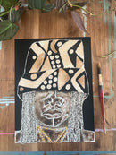 Artistic depiction of a face with abstract patterns on a wooden surface with a paintbrush.