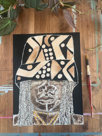 Artistic depiction of a face with abstract patterns on a wooden surface with a paintbrush.